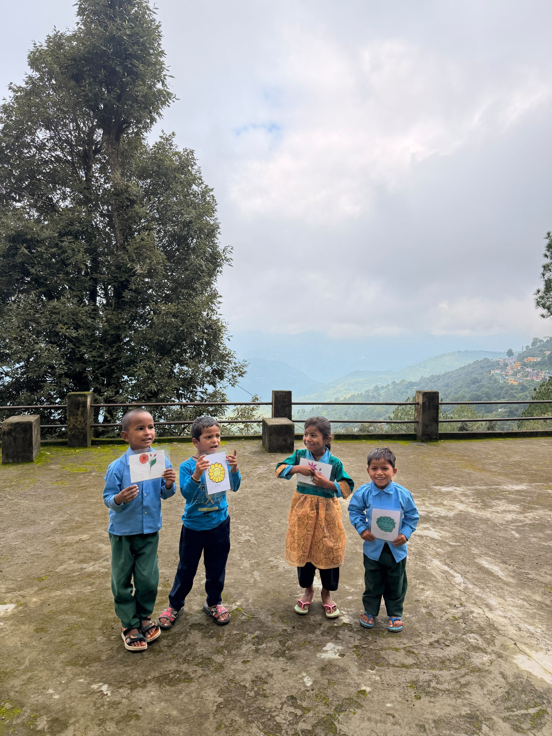 Four children standing on the hillside under an open sky