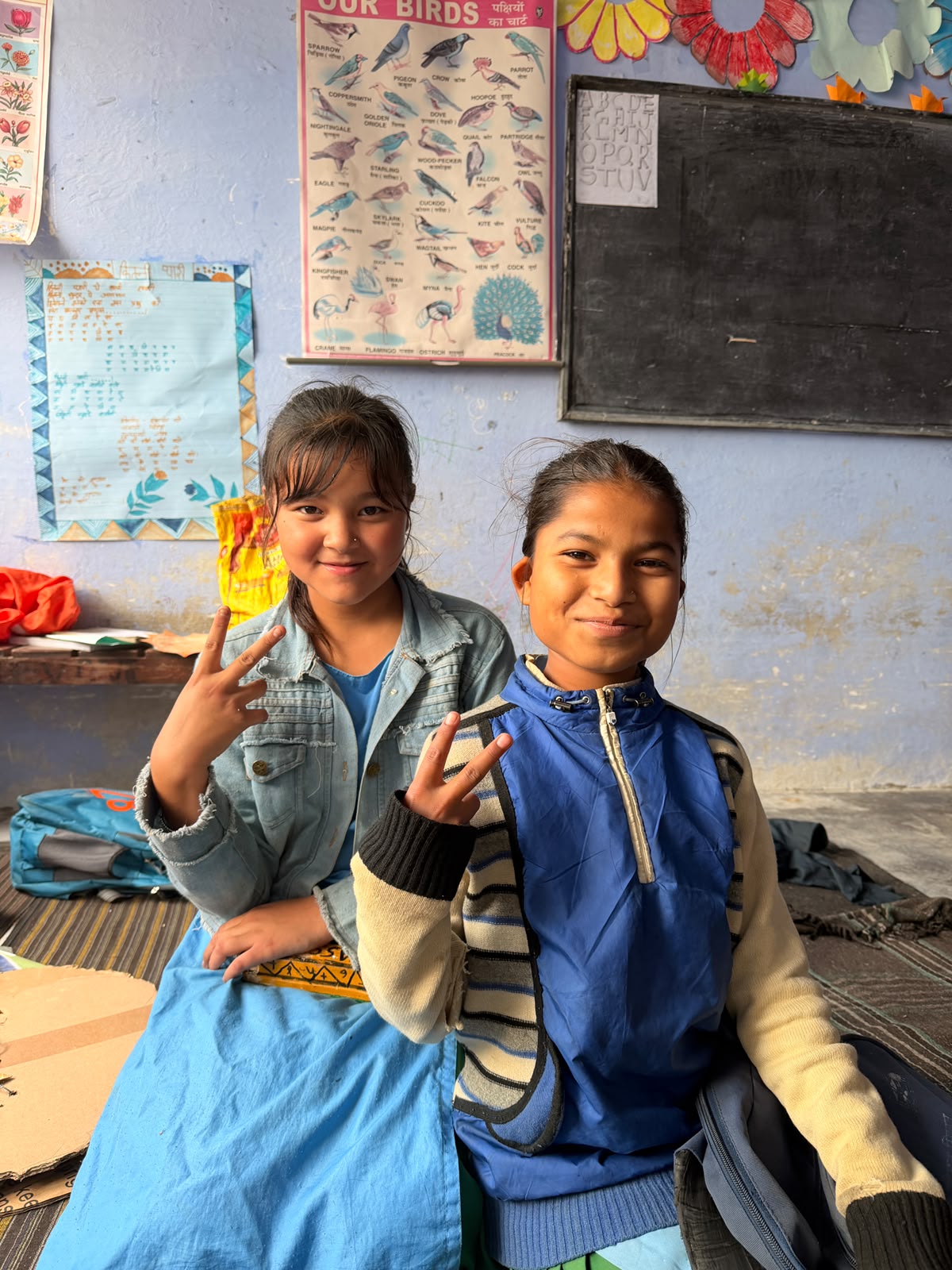 Two students in class, one holding up a peace sign